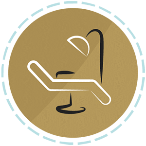 Gold circular icon of a dental chair and overhead light representing sedation dentistry and patient comfort.