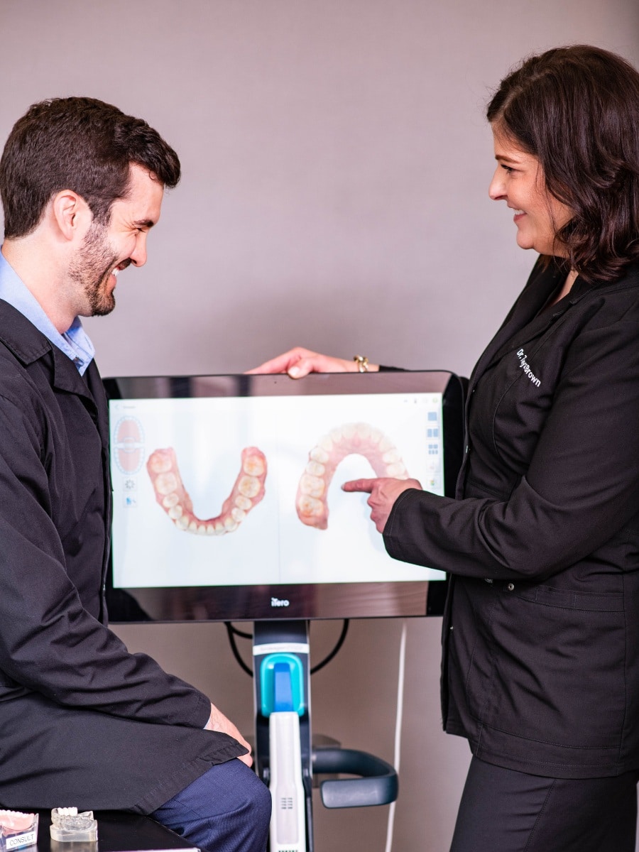 Dentist and patient reviewing 3d digital scan for dental implant treatment at the center for cosmetic and restorative dentistry in chesapeake, va.