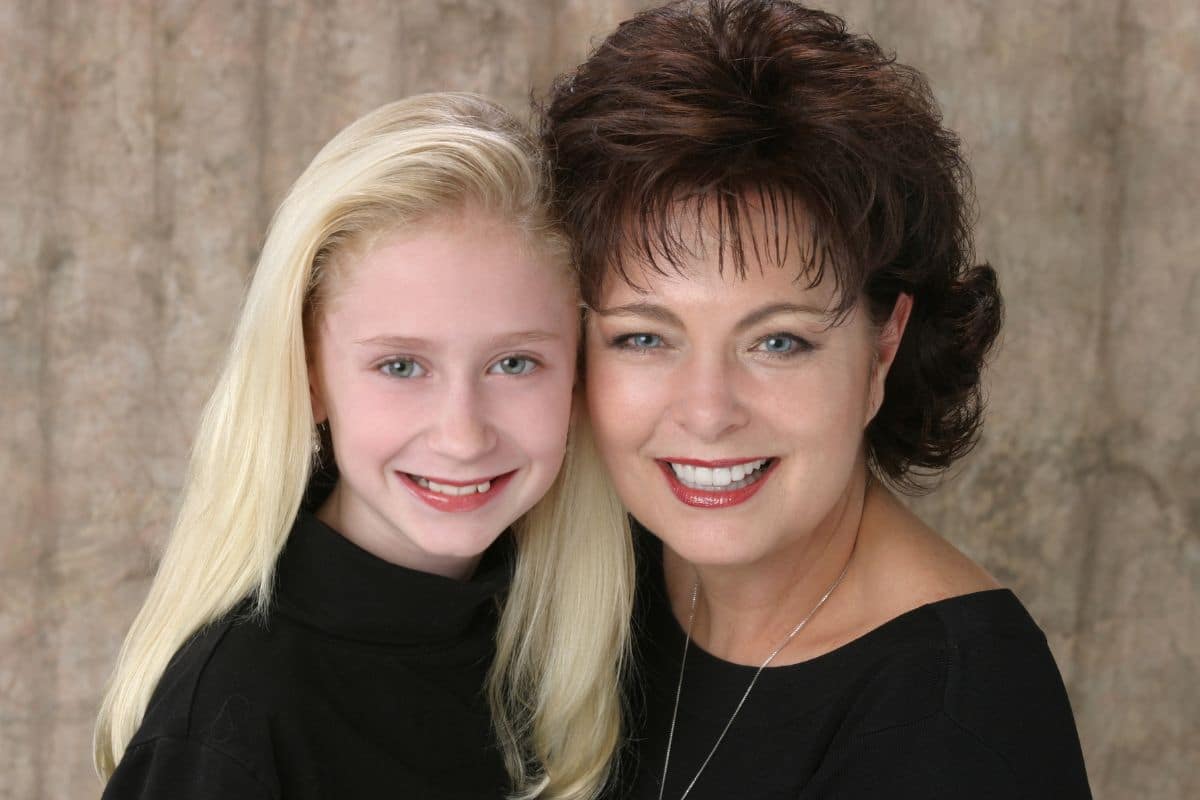 Mother with brown curly hair smiling with her blonde-haired daughter at a chesapeake va dental office.