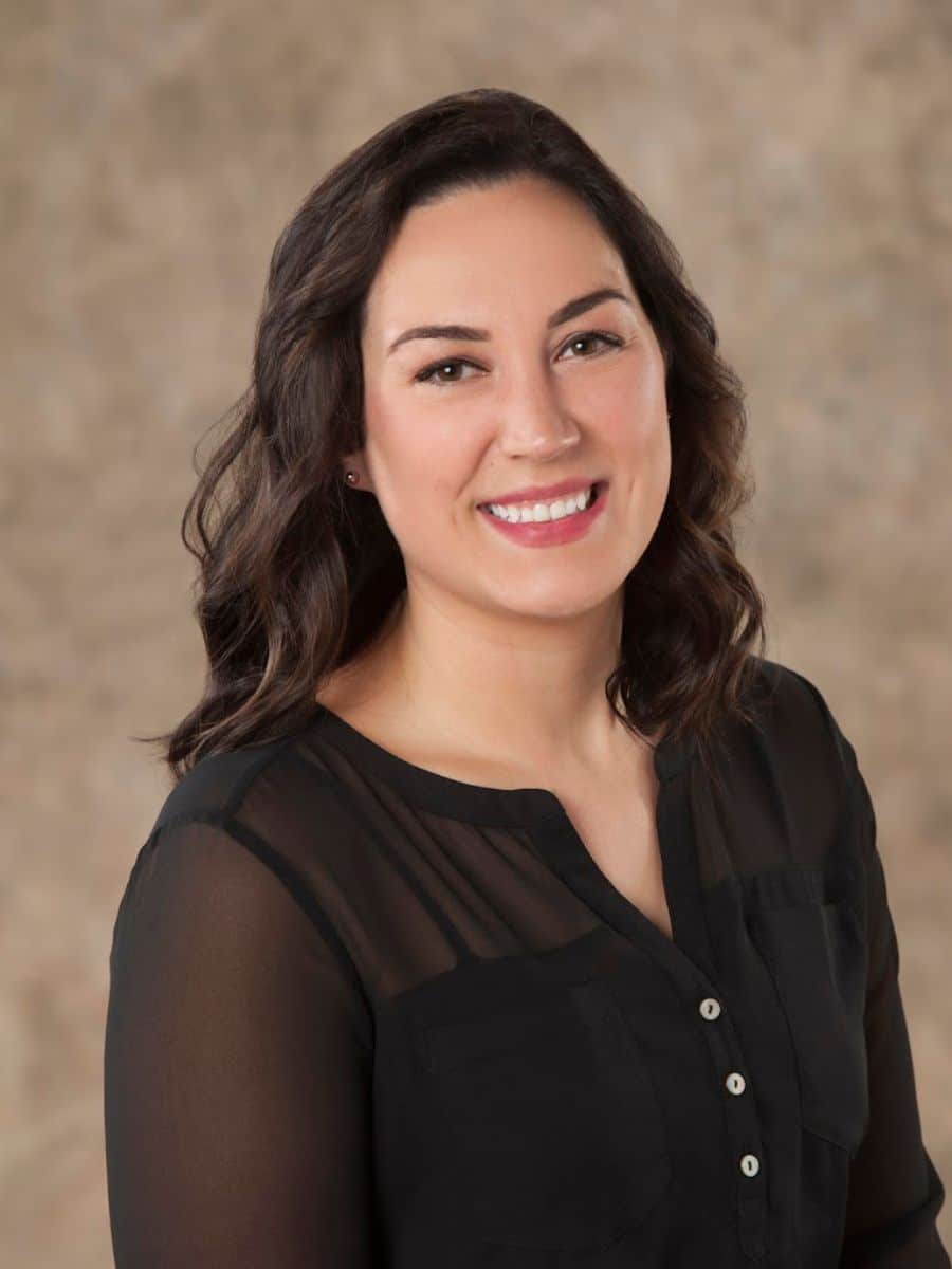 Woman with black curly hair smiling after receiving a porcelain crown in chesapeake va.