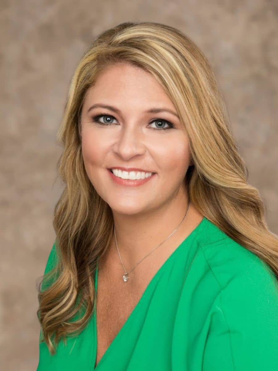 Blonde woman wearing a green shirt smiling after teeth whitening in chesapeake va.