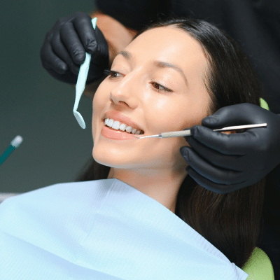 Woman smiling while receiving dental work, representing restorative and cosmetic dentists in chesapeake va