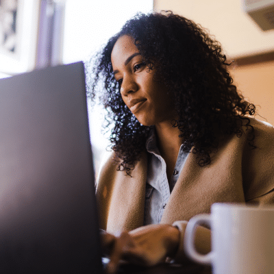 Woman working on a laptop computer, representing the center for cosmetic and restorative dentistrys new website