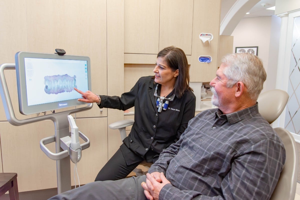 Expert chesapeake dentist reviewing digital dental scan with a patient during a dental implant consultation.