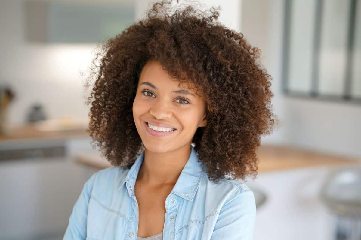 Woman with curly hair smiling after cosmetic bonding at the center for cosmetic and restorative dentistry in chesapeake, va