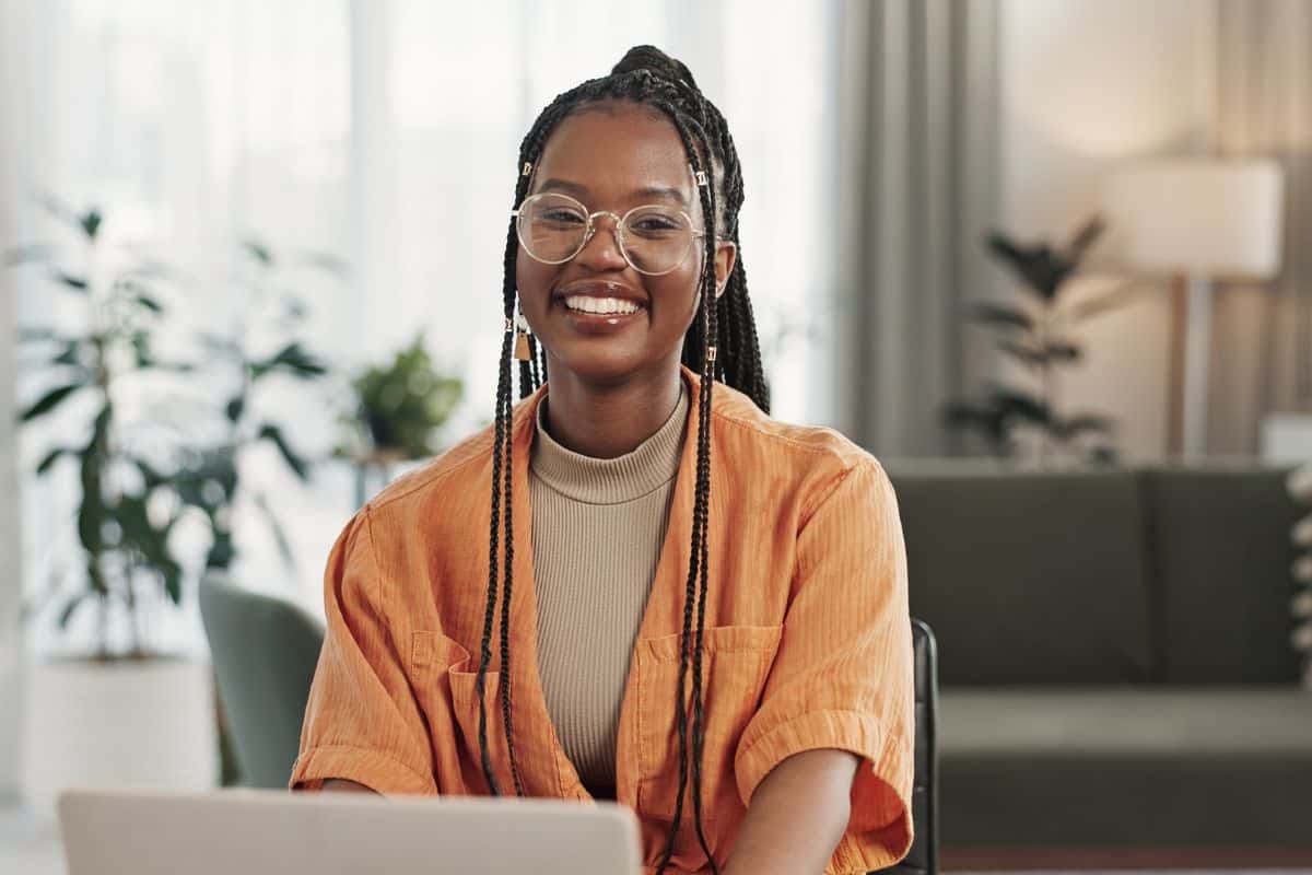 Woman wearing glasses smiling after porcelain crowns and bridges at the center for cosmetic and restorative dentistry in chesapeake, va