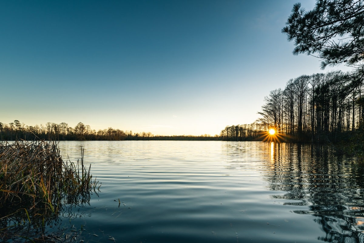 Sunset over Northwest River Park in Hickory, Virginia, reflecting on calm water surrounded by trees.