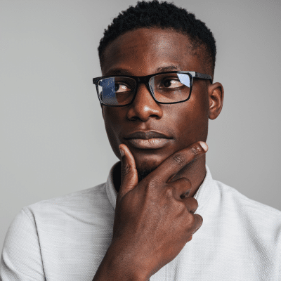 Man thinking with hand on chin, representing restorative vs cosmetic dentistry