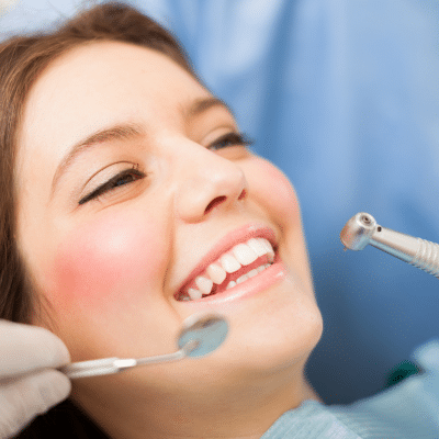 Woman smiling at the dentist, representing what to expect at your first dental visit