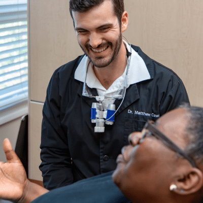 Dr. Matthew cawley talking to a patient, representing the importance of regular dental exams
