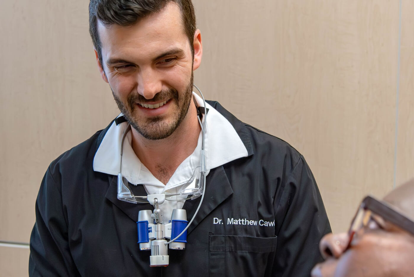 Home 5 Dr. Matthew Cawley talking to a patient, representing the importance of regular dental exams